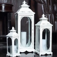 Set of three white decorative lanterns with candles inside on a dark background