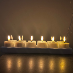 Row of lit LED candles on a dark background