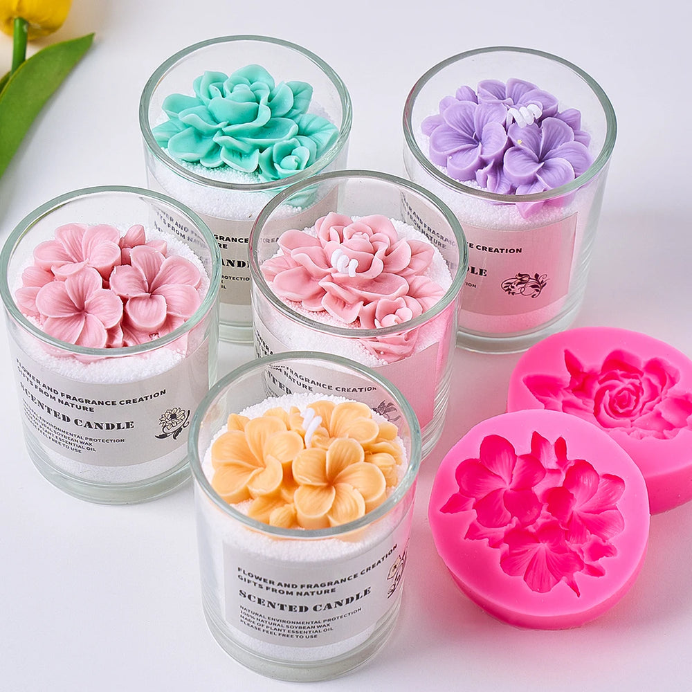 Set of scented candles with floral designs and a pink silicone mold on a light background.
