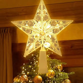 Decorative star tree topper on a Christmas tree with warm lighting.