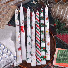 Set of Christmas-themed candles on a decorative surface with festive decor.