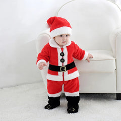 Baby wearing a red Santa Claus outfit standing on a white carpet.