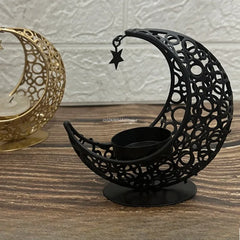Decorative black metal candle holder shaped like a crescent moon with a star on a wooden surface.