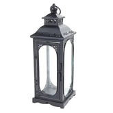 Black metal lantern with decorative design on a white background