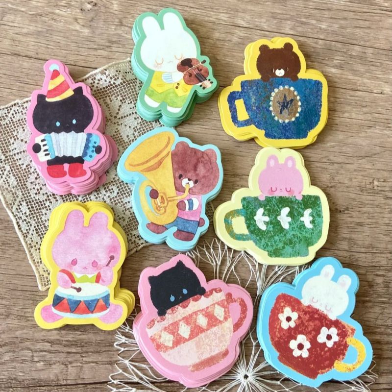 Set of colorful animal-themed stickers on a wooden surface