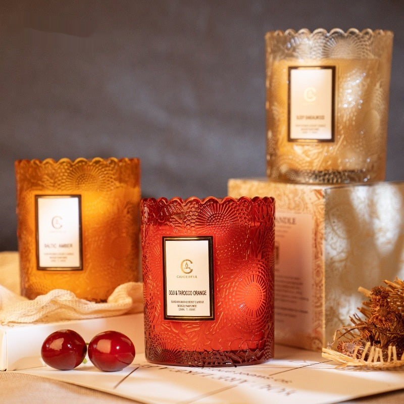 Decorative candles with embossed designs on a textured surface