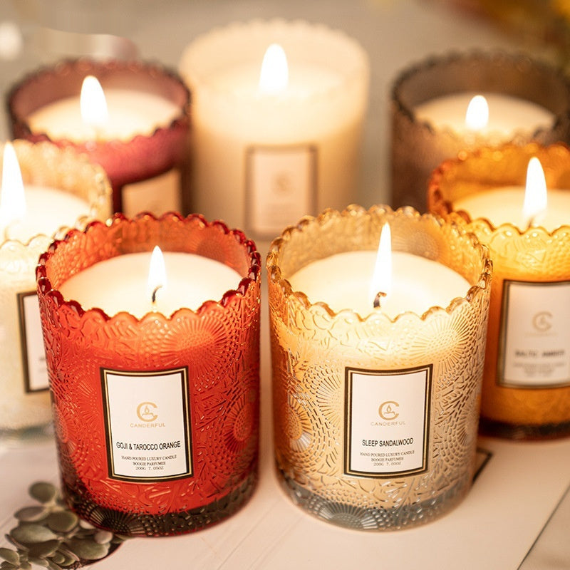 Decorative candles with labels in various colors on a surface.