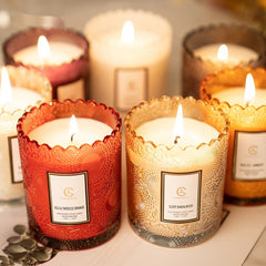 Decorative candles with labels in various colors on a surface.