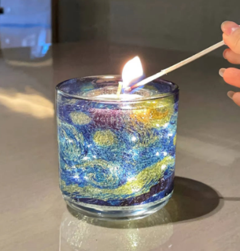 Candle being lit with a match in a glass holder featuring a colorful design.