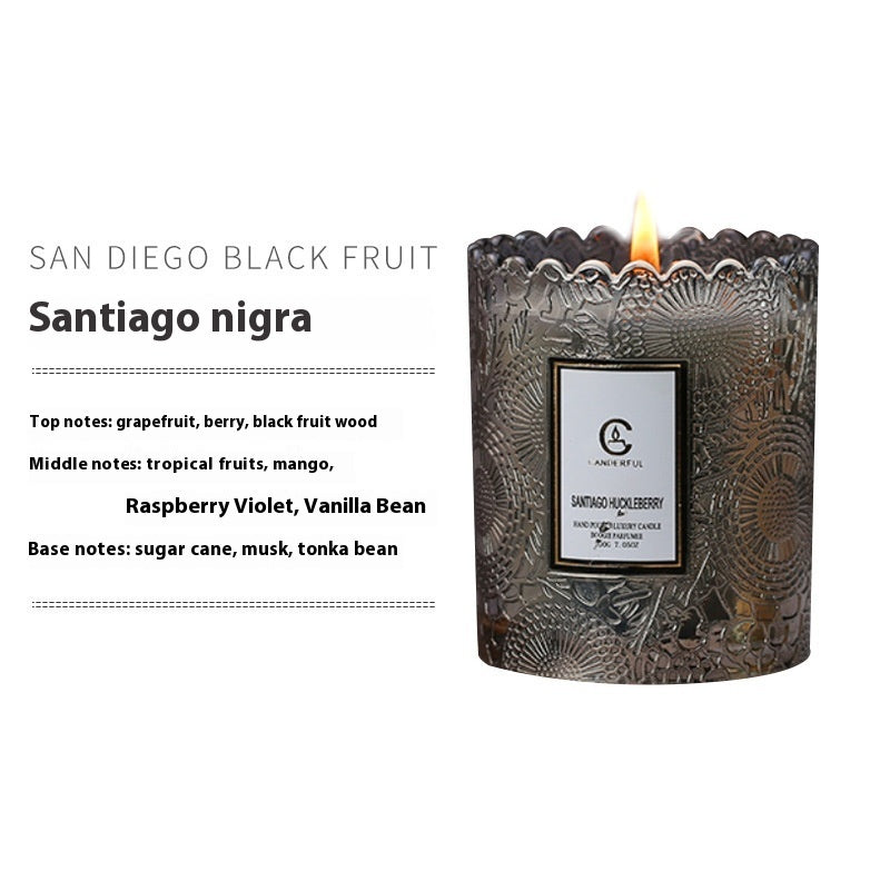 Decorative candle with intricate design and 'San Diego Black Fruit Santiago nigra' label on a white background