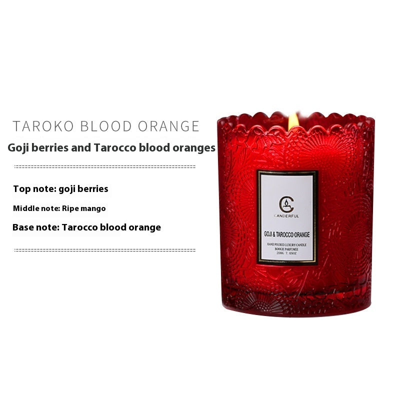 Red candle with a label on a white background, featuring notes of goji berries and Tarocco blood oranges.
