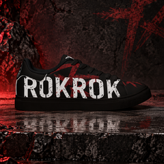 A black low-top sneaker with the word 'ROKROK' in distressed white letters across the side, set against a dark, gritty background with red lighting and reflective wet stone.