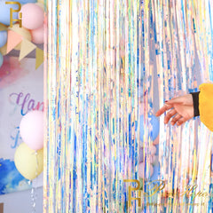 Colorful tinsel curtain with balloons and a hand reaching out, featuring the brand 'PP'.