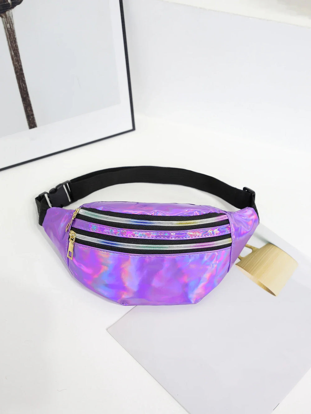 Purple reflective fanny pack on a white surface with a blurred background