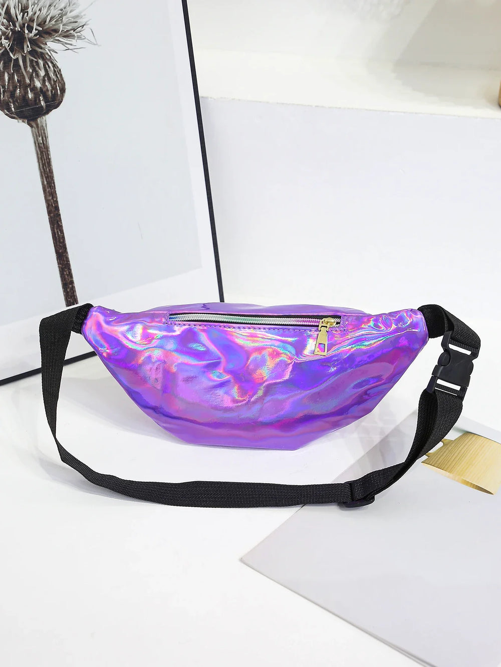 Holographic purple fanny pack on a white surface with a minimal background