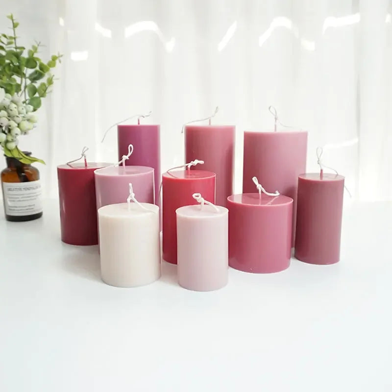 Set of pink and white candles on a white surface with a blurred background