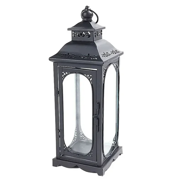 Black metal lantern with decorative design on a white background