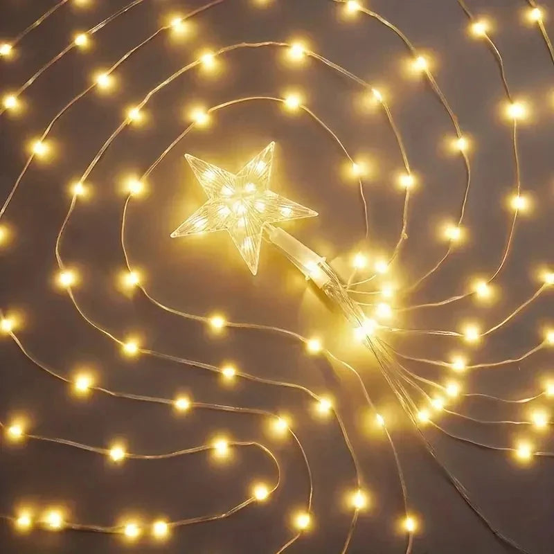 Star-shaped fairy light wand with string lights on a dark background
