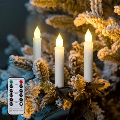 Decorative candles with a remote control on a branch with snow and pine cones.
