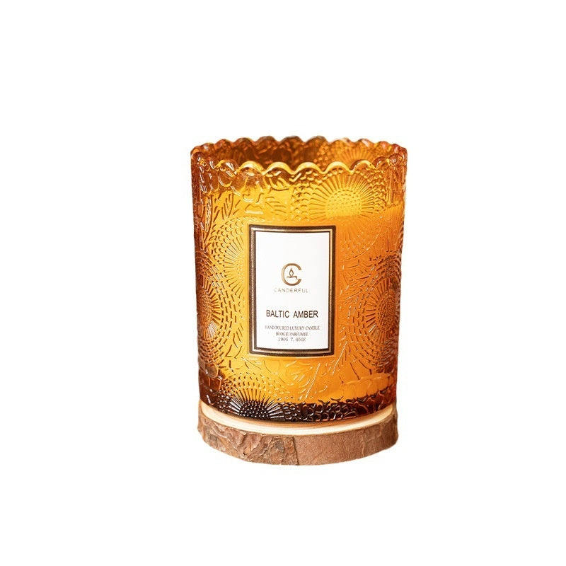 Decorative candle with textured glass and wooden base on a white background
