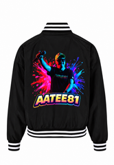 A black varsity-style bomber jacket shown from the back, featuring a large colorful graphic of a person with a paint splatter background and the text 'AATEE81' in bold outlined lettering. The jacket has white and black striped ribbed collar, cuffs, and hem.