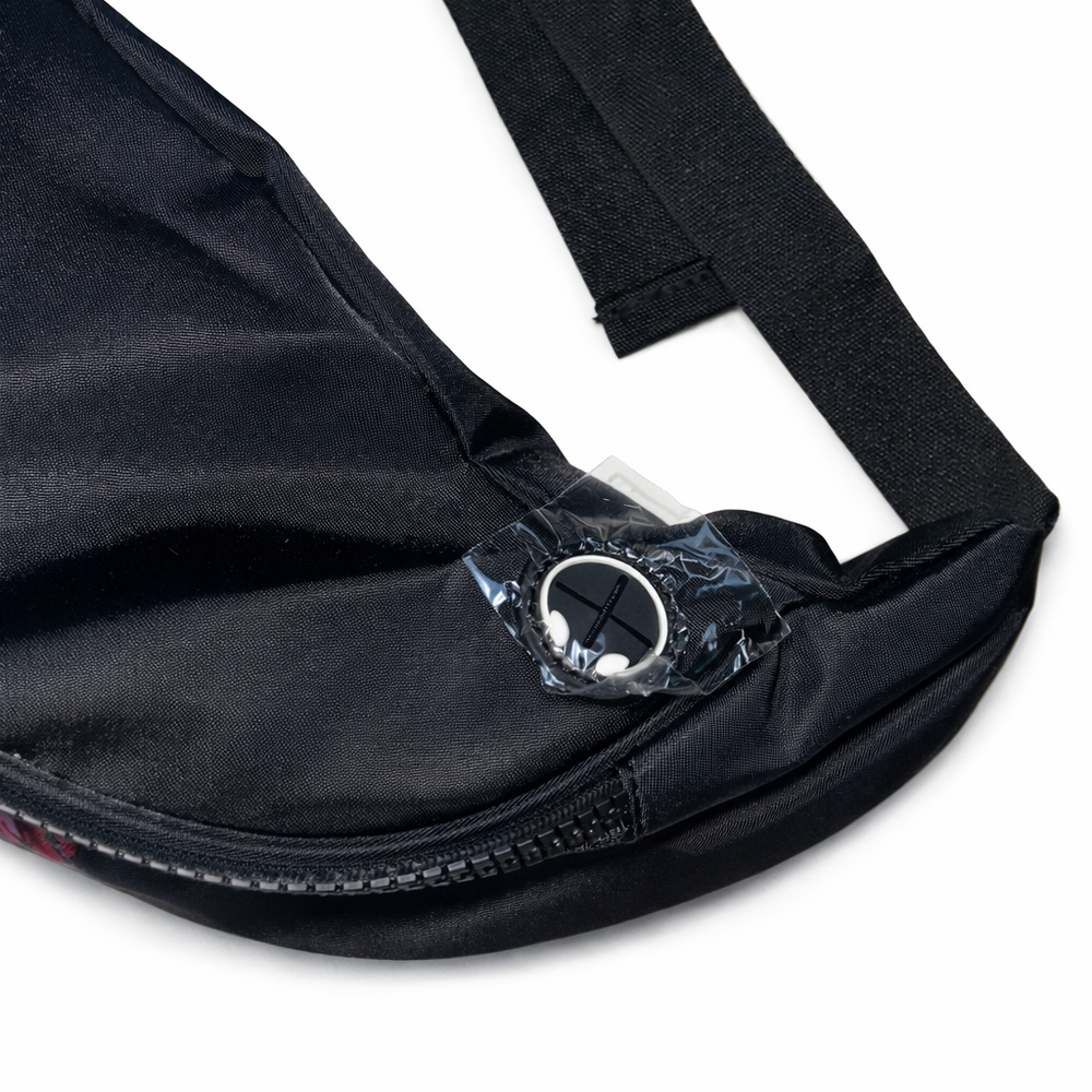 Close-up of a black bag with a strap and zipper on a white background