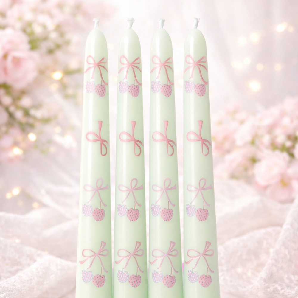 Five green candles with decorative patterns on a soft white background
